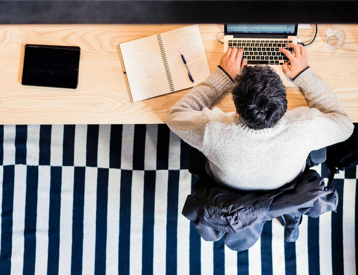 Business owner working at a desk with a laptop and notebook